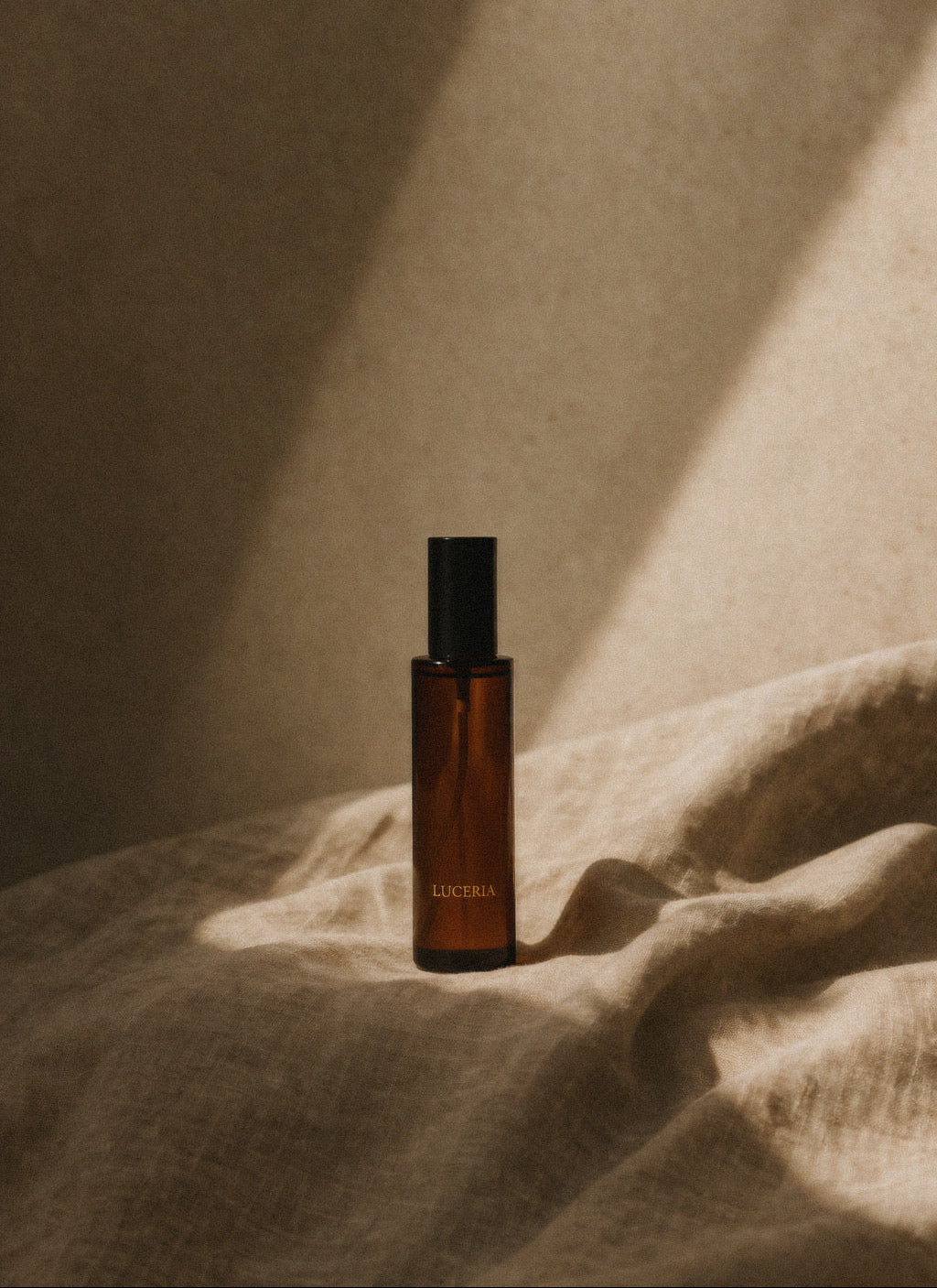 Brown Luceria bottle with black cap on a textured surface with soft lighting