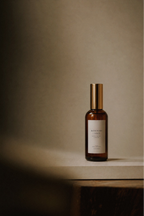 Luceria's rosemary and sage scented room spray in a neutral textured background