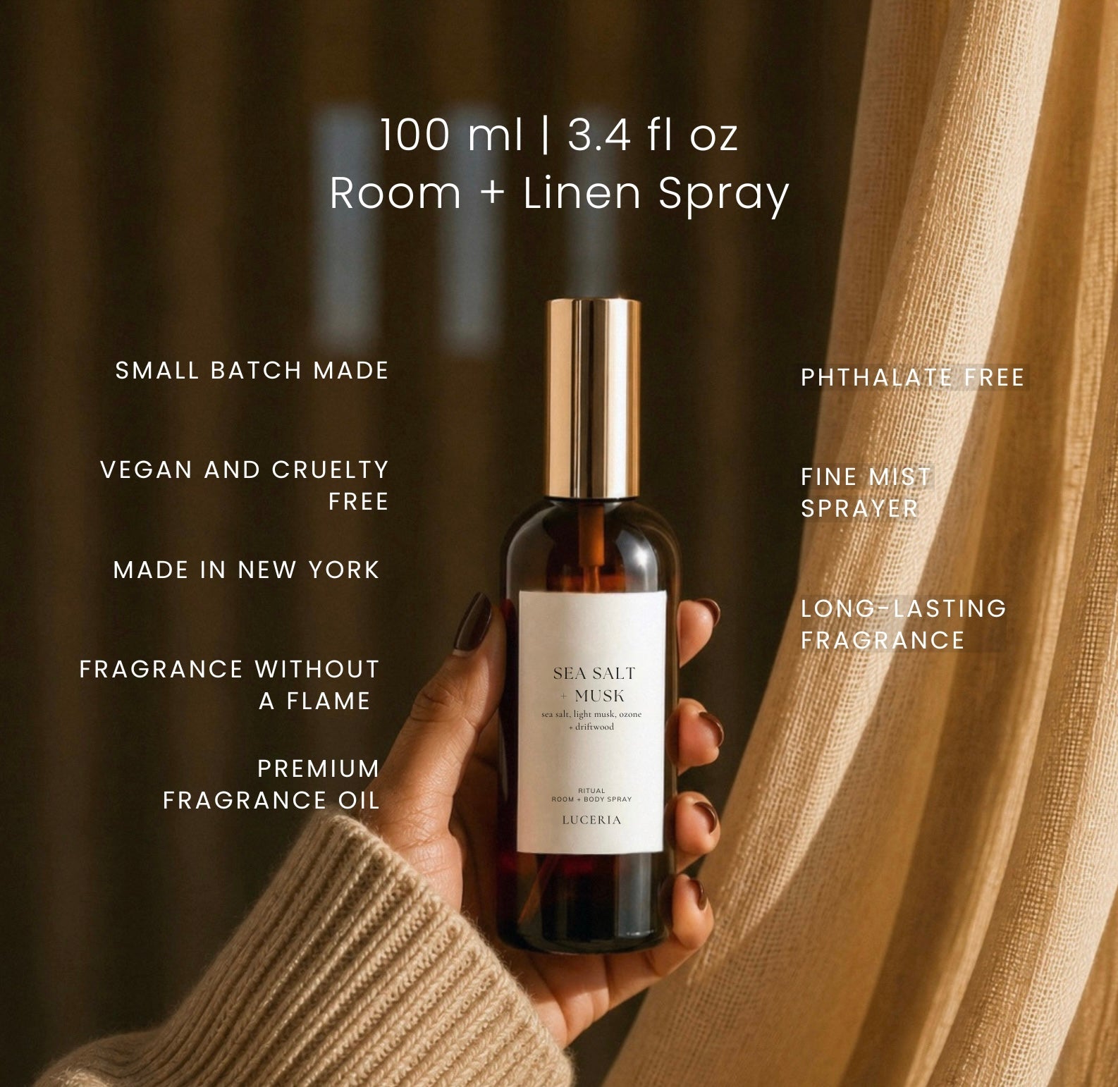 A hand holds a bottle of Luceria Sea Salt and Must room and linen spray against a warm background of dark brown curtains and beige drapes. White text overlays describe the product's features and specifications.