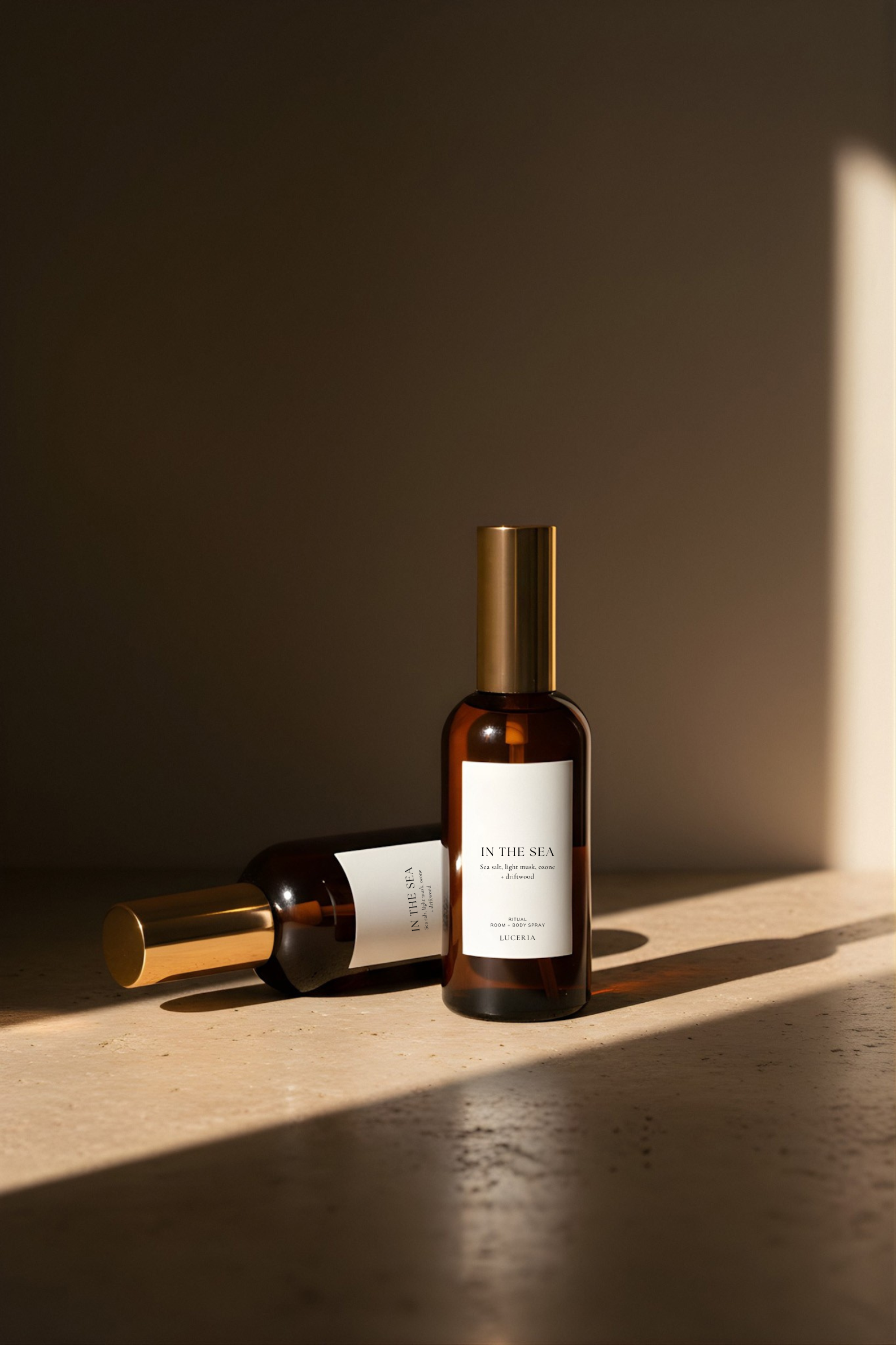 Two brown In the Sea bottles with gold caps on a wooden surface with a dark background