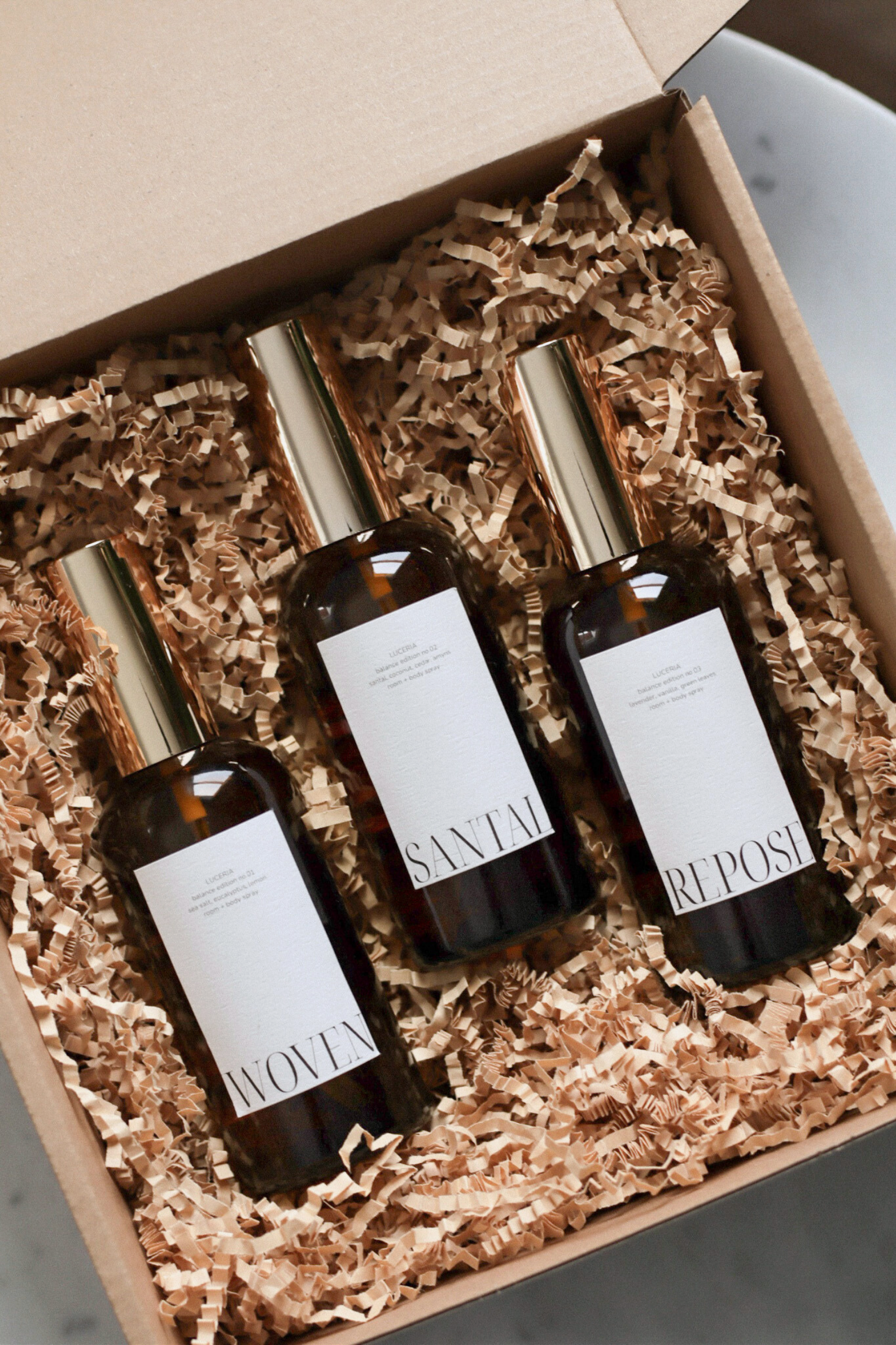Luceria Candle Co. Spray Trio Bundle featuring amber bottles of room + body mist on a soft neutral surface. handcrafted, plant-based, and designed for holiday gifting.