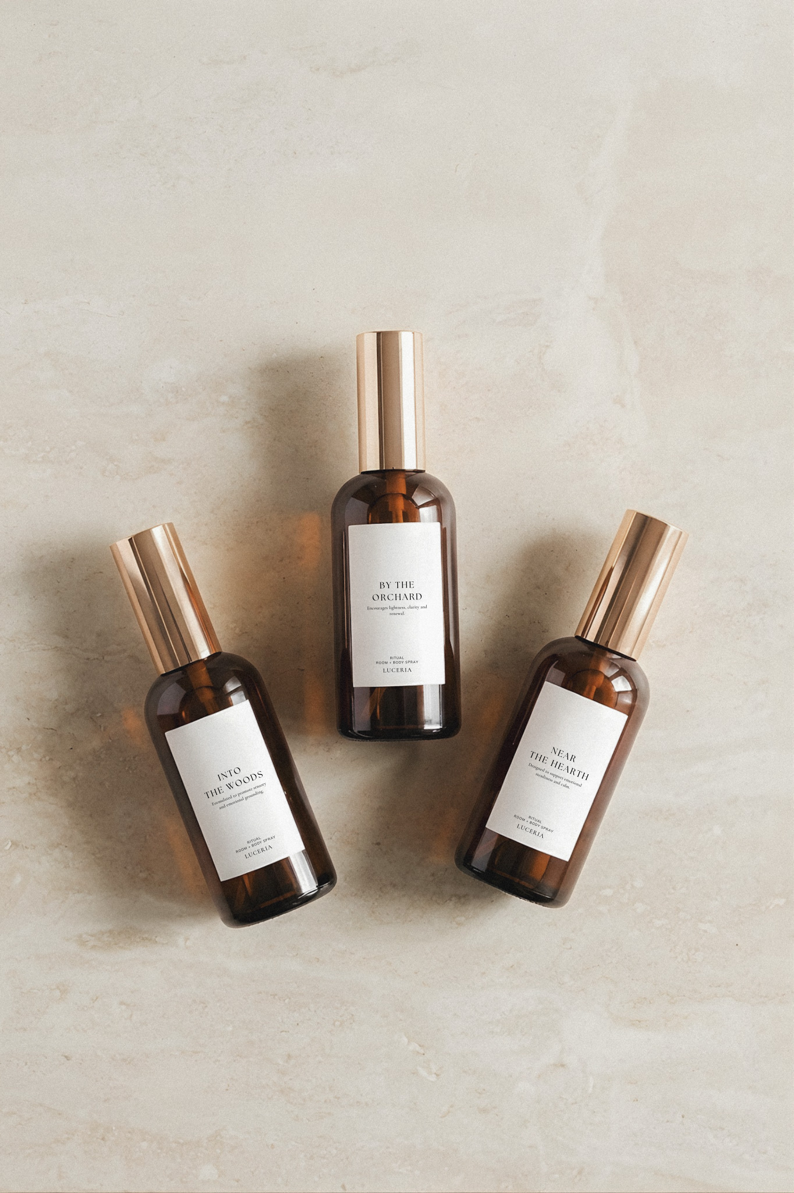 Three brown glass bottles with bronze caps on a beige background