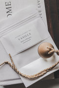 Vanilla-scented room diffuser packaging with wooden diffuser on a textured surface