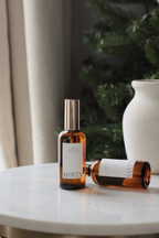 Two bottles of 'Woven' on a marble surface with a blurred background