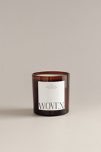 Soft Eucalyptus scented candle with 'Woven' label on a beige background