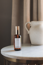 Bottle labeled 'Woven' on a marble surface with a neutral background